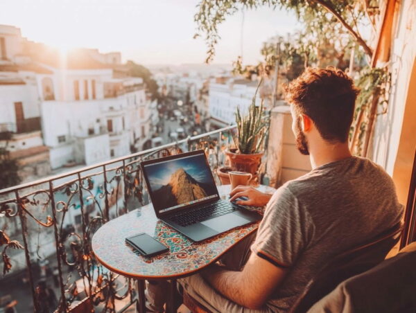 Digitaler Nomade arbeitet auf einer Terrasse mit Blick auf die Stadt