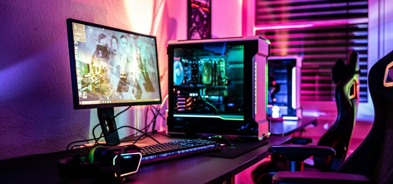 Beleuchtetes Gaming-PC-Setup mit Monitor, Tastatur und Headset in einem modernen Raum