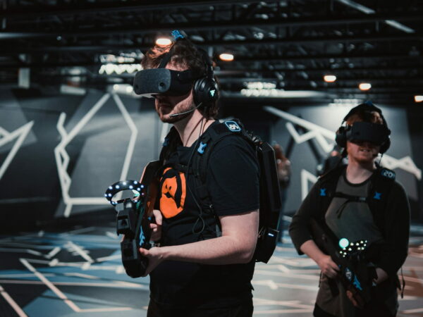 Zwei Personen mit VR-Headsets und Controllern in einem modernen Gaming-Setup