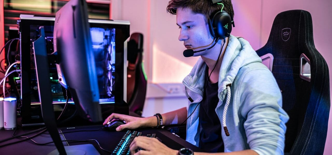 Gamer mit Headset vor einem Monitor, Blaulichtfilter für Augenschutz