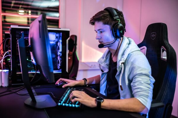 Gamer mit Headset vor einem Monitor, Blaulichtfilter für Augenschutz