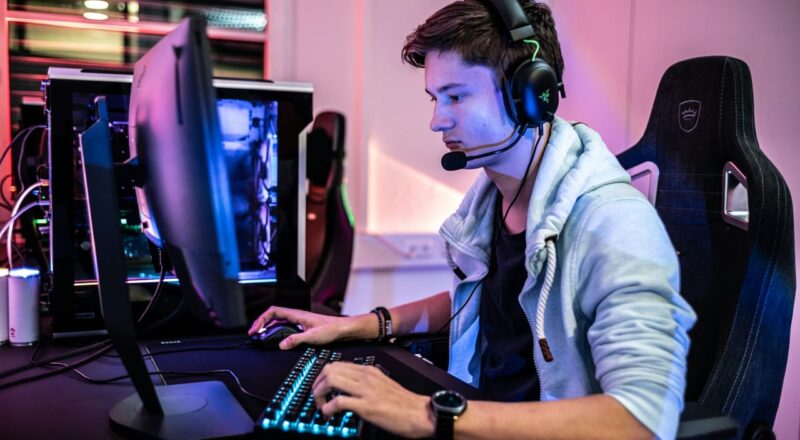 Gamer mit Headset vor einem Monitor, Blaulichtfilter für Augenschutz