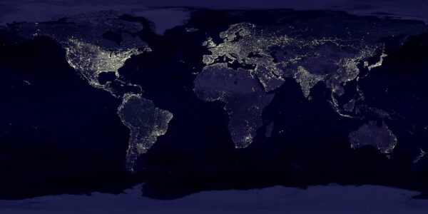 Weltkarte bei Nacht mit globaler Vernetzung – Auswirkungen des AI Act auf internationale KI-Dienste.